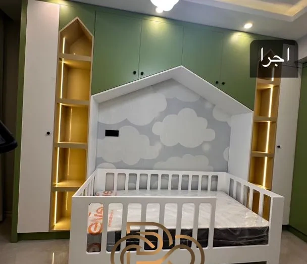 عکس واقعی اجرای همان اتاق کودک: تخت خانه‌ای، قفسه‌های نوردار و کمد سبز نصب‌شده